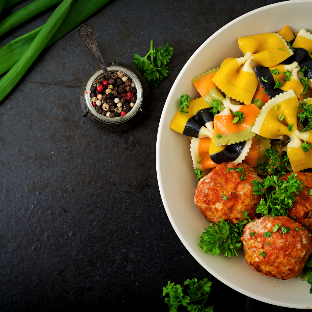 Паста с тефтелями и салатом в тарелке