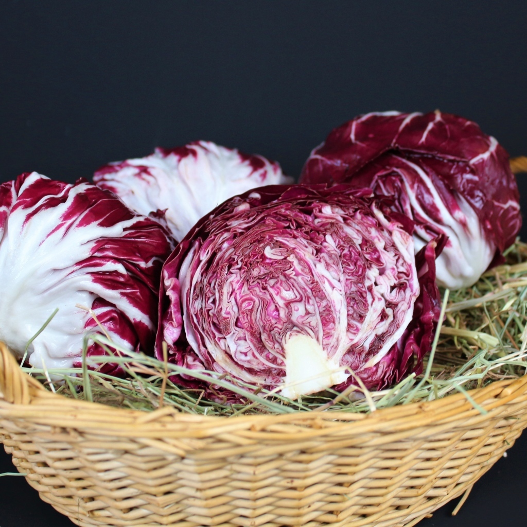 Красная капуста в корзине на черном фоне