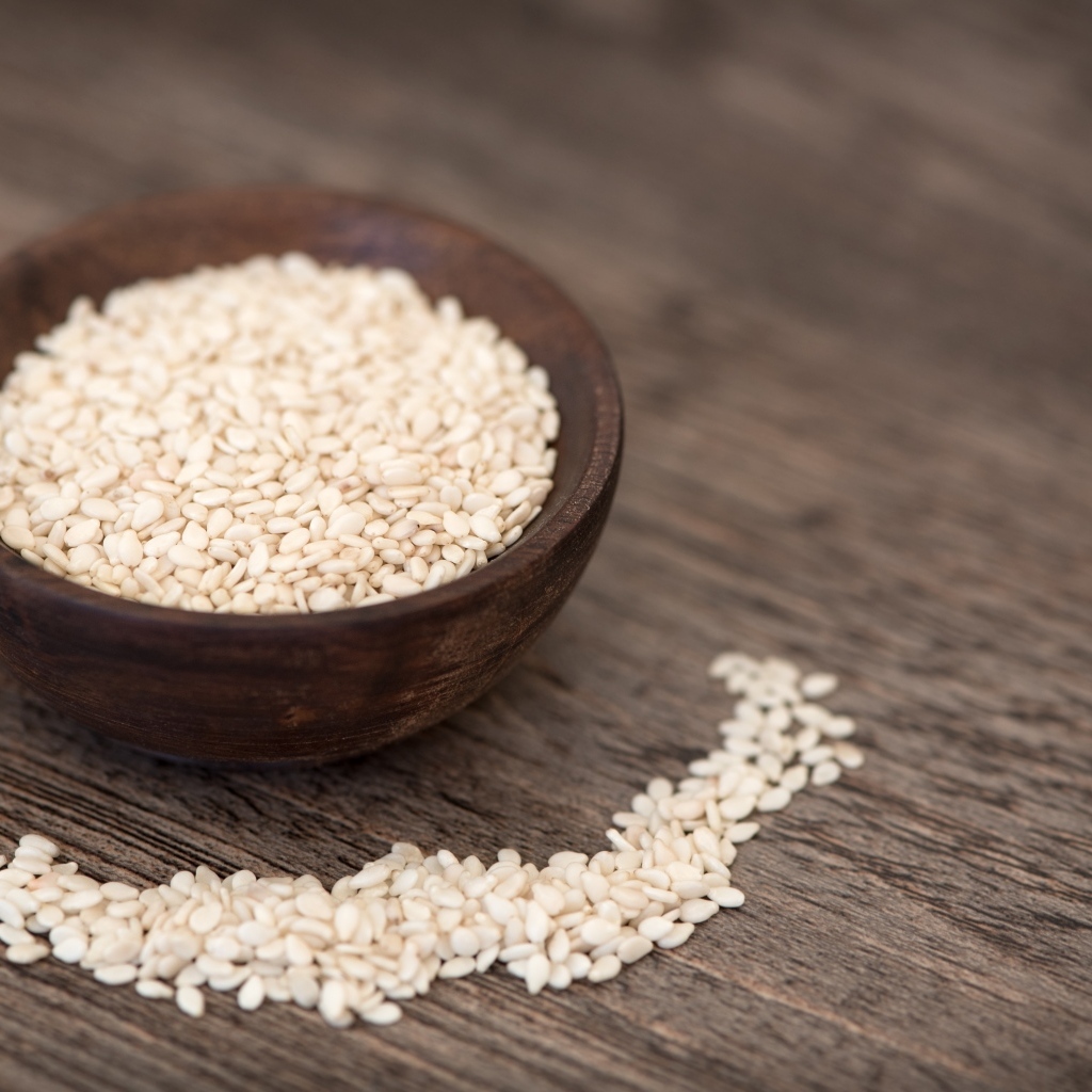 Зерна кунжута в деревянной миске на столе