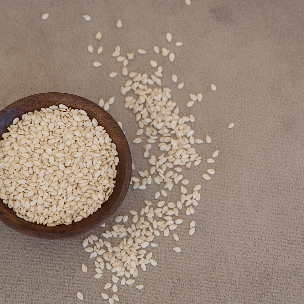 Зерна кунжута в деревянной миске на столе