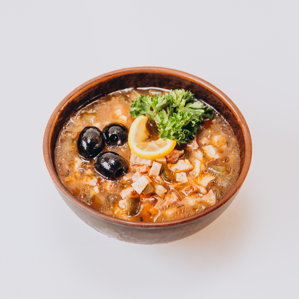 Солянка в тарелке на сером фоне