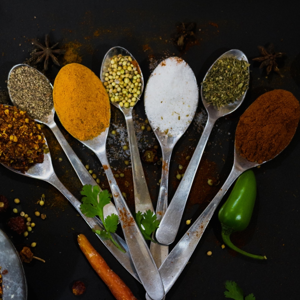 Ложки с ароматными специями на черном столе