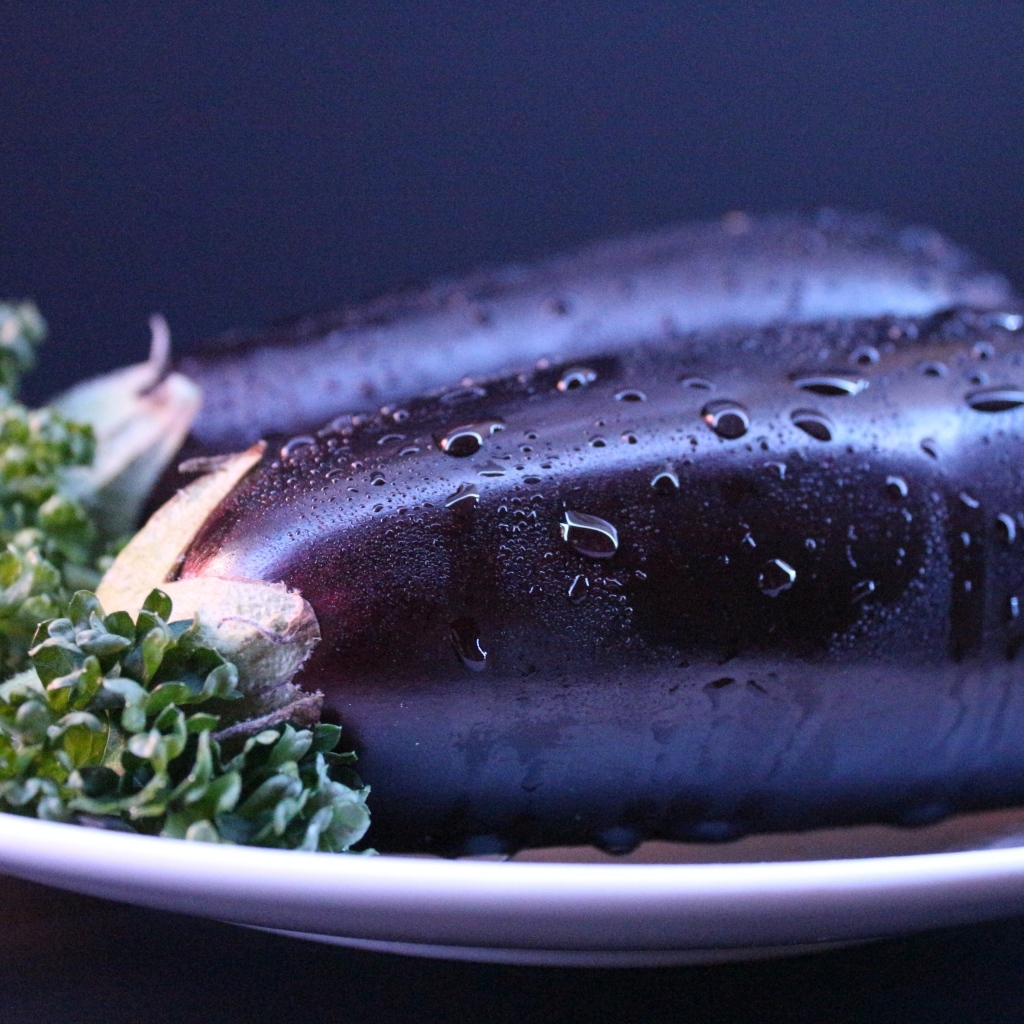 Два баклажана на тарелке с зеленью