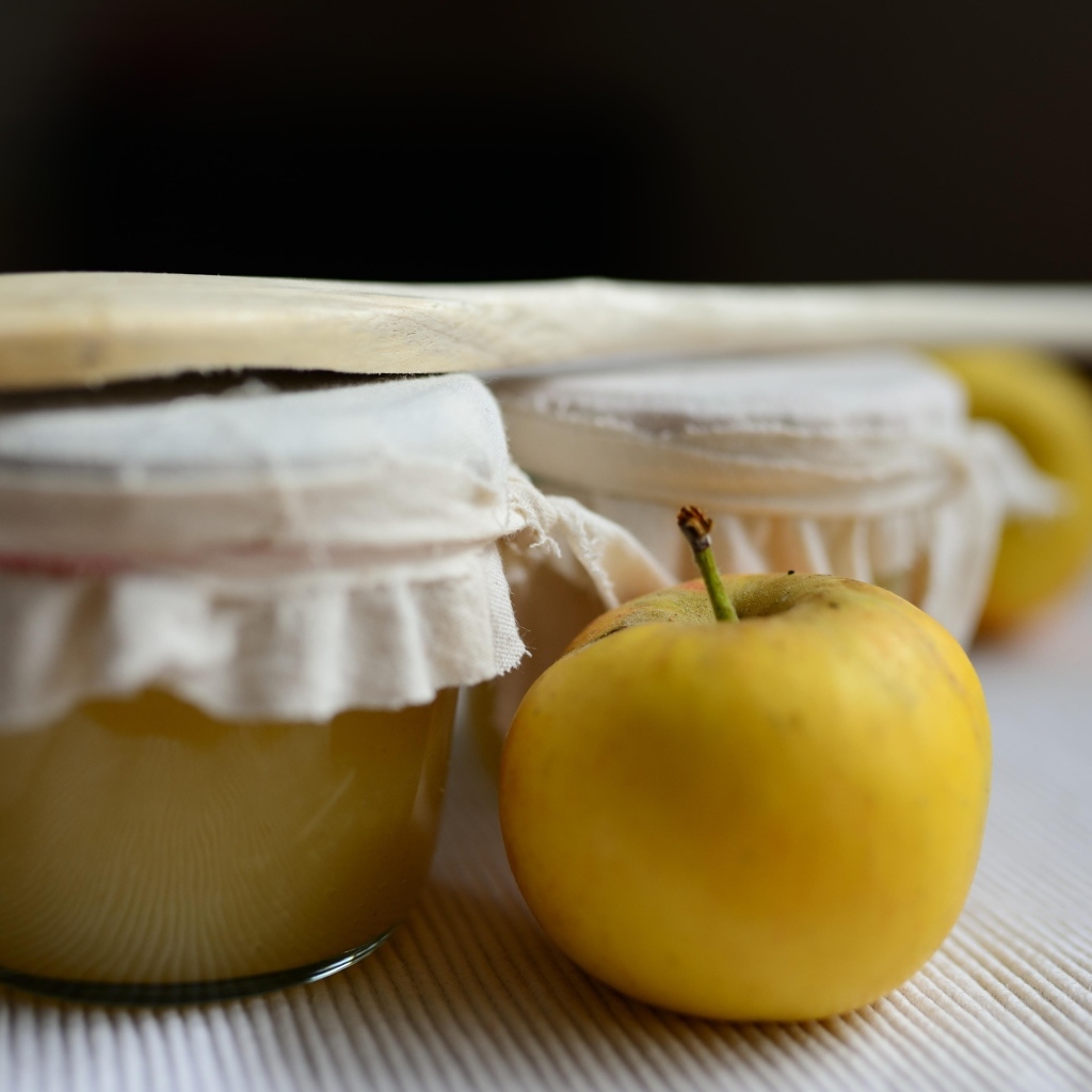 Яблочное пюре в банке на столе с плодами