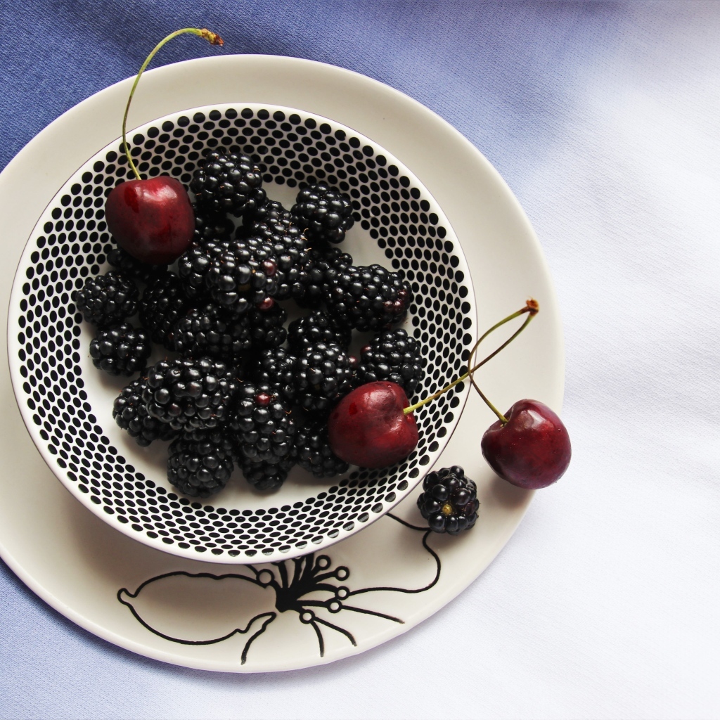 Ягоды ежевики и черешни на столе