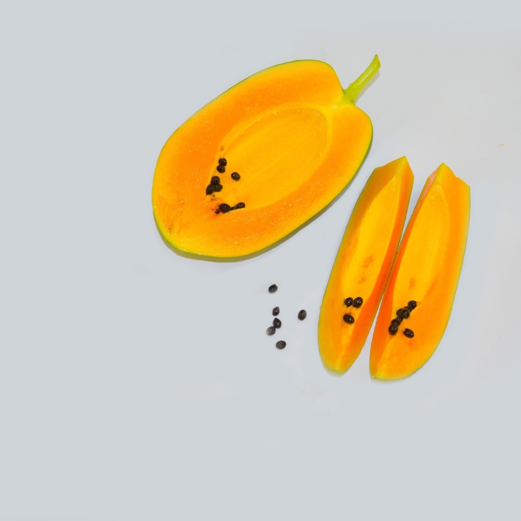 Разрезанная папайя на сером фоне