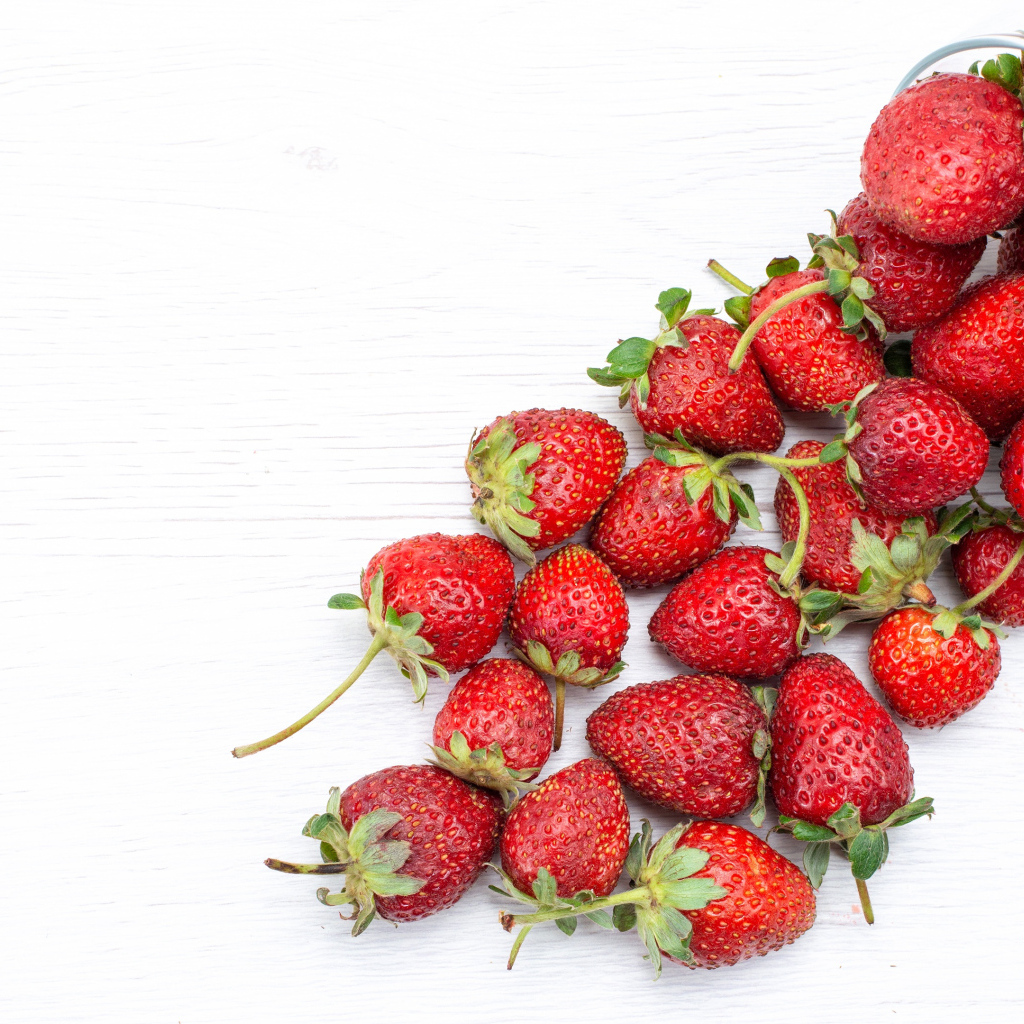 Стеклянный стакан с ягодами клубники на столе