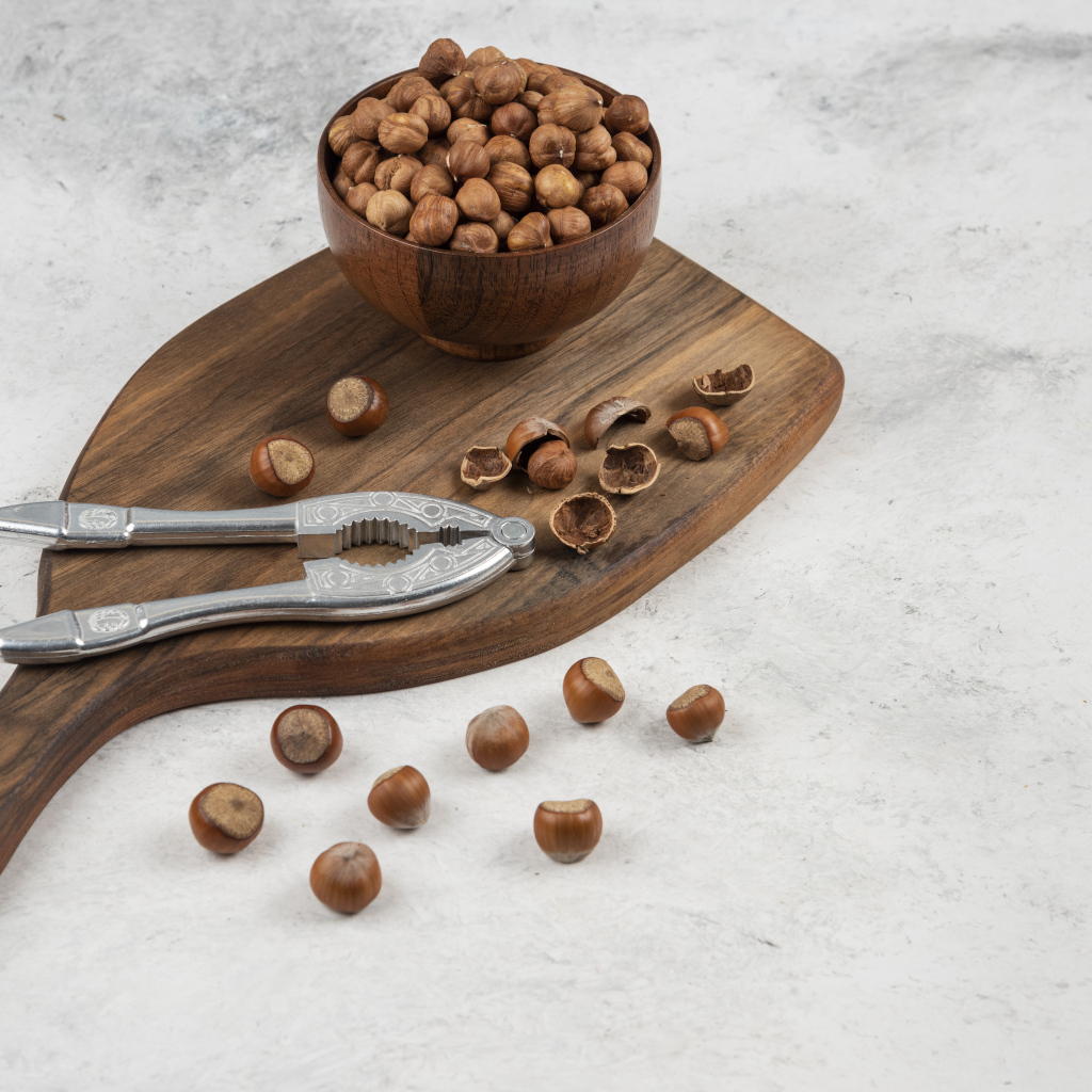 Лесные орехи на сером столе с разделочной доской