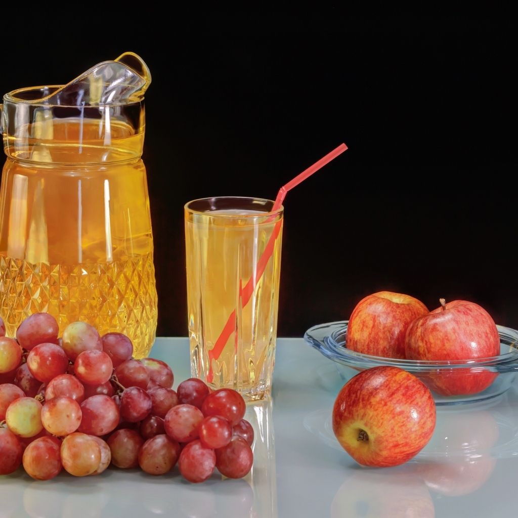 Сок на столе с виноградом и яблоками