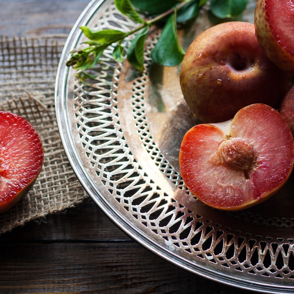 Сочные сливы на тарелке на столе