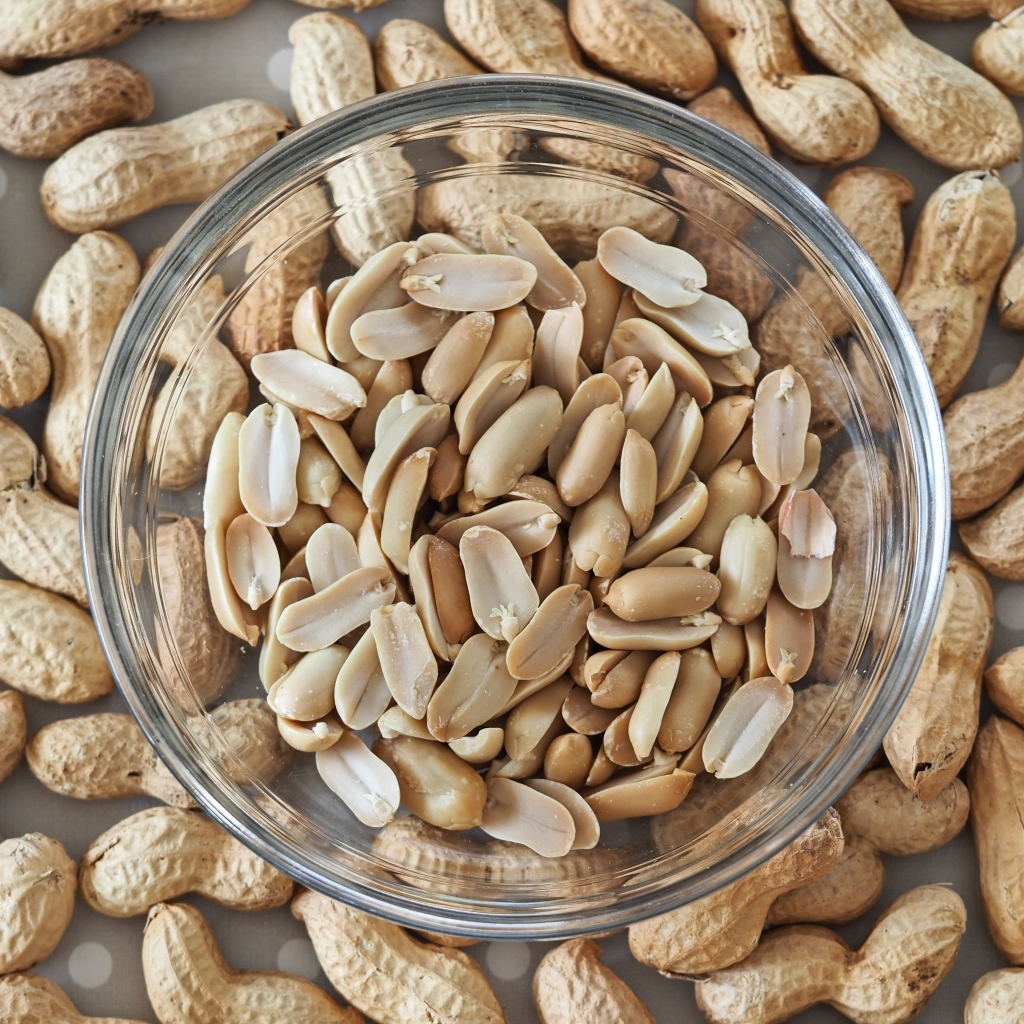 Арахис в стеклянной тарелке на столе 
