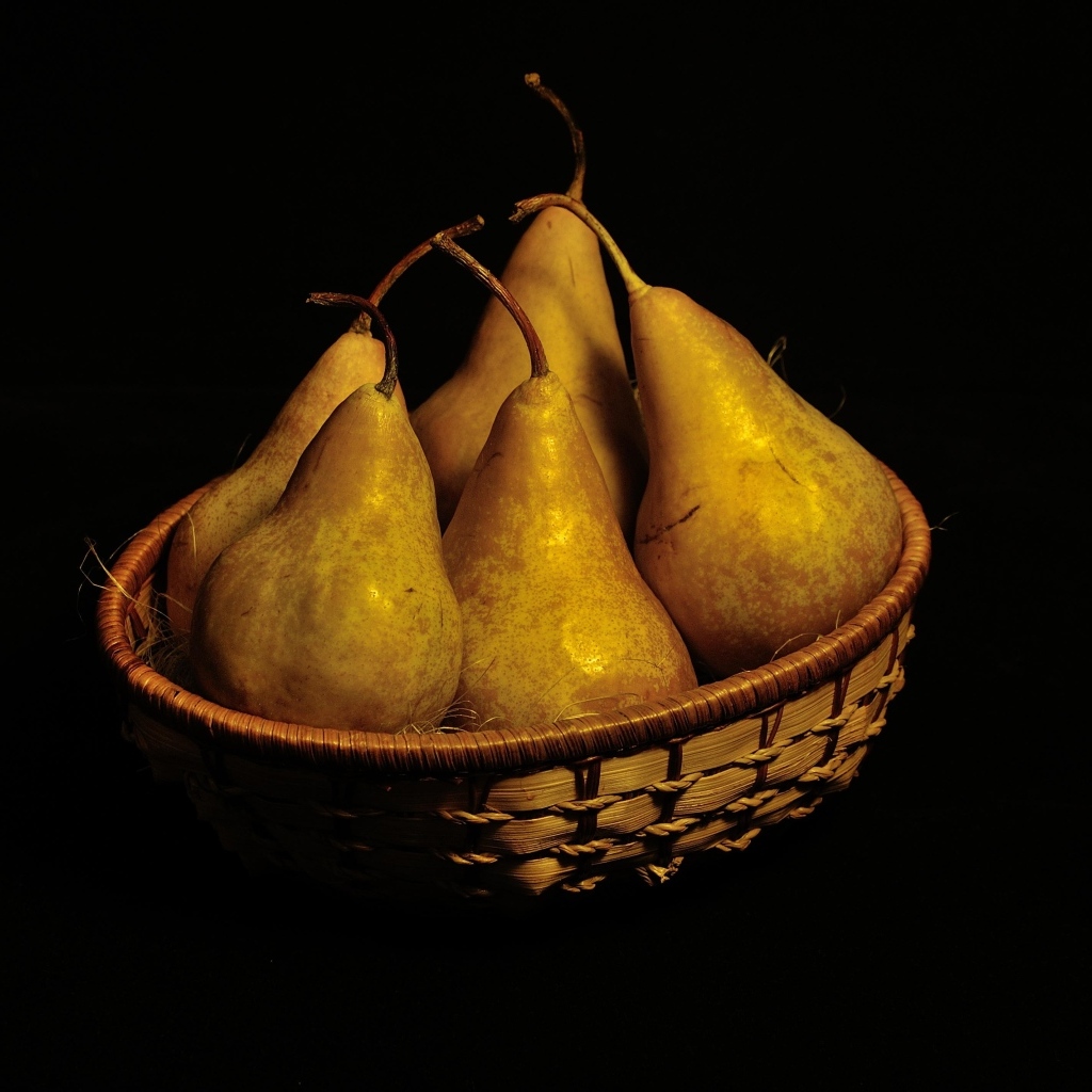 Груши в корзинке на черном фоне