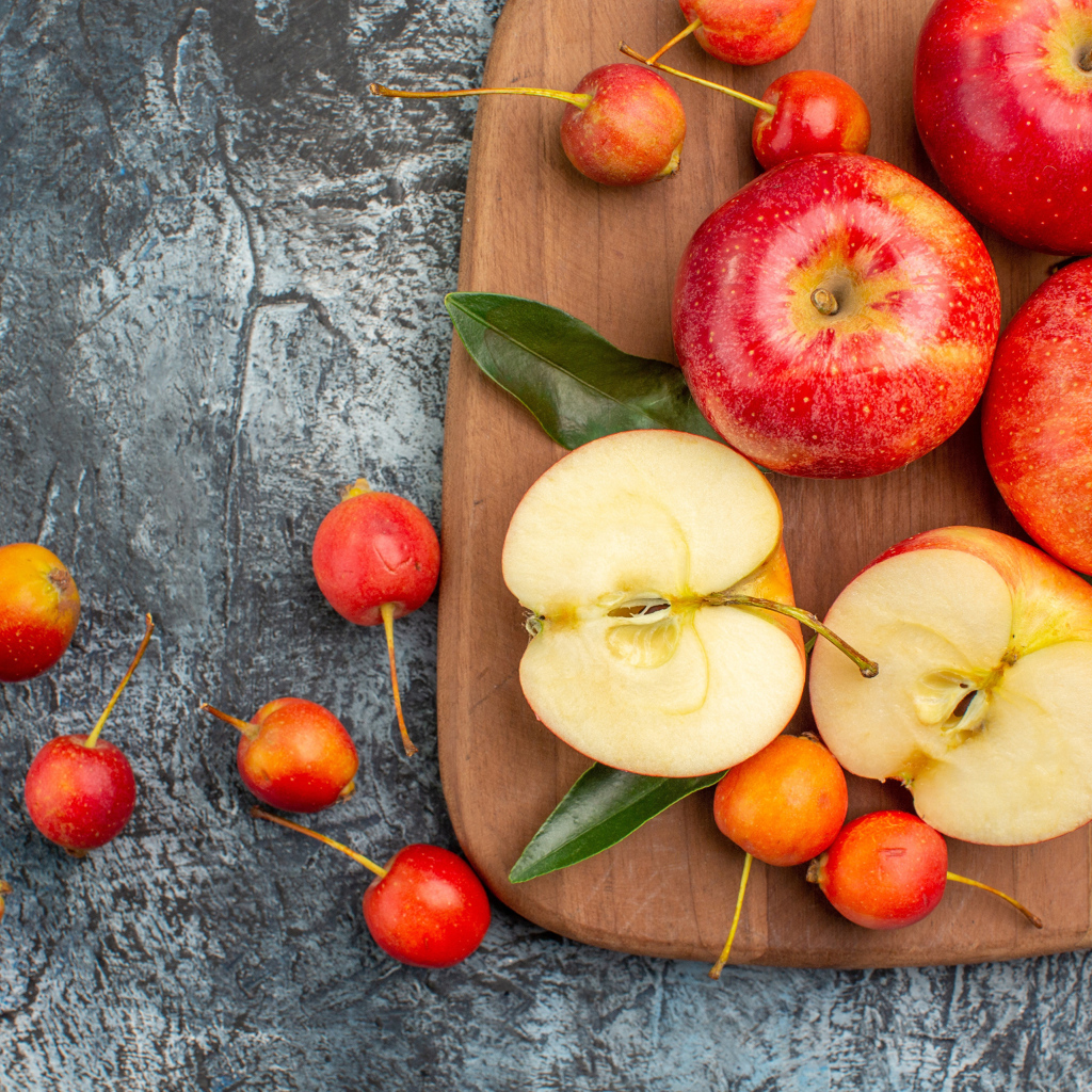 Нарезанные яблоки на деревянной доске на столе