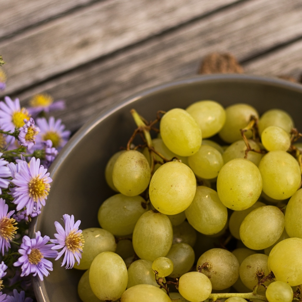 Белый виноград в миске с цветами