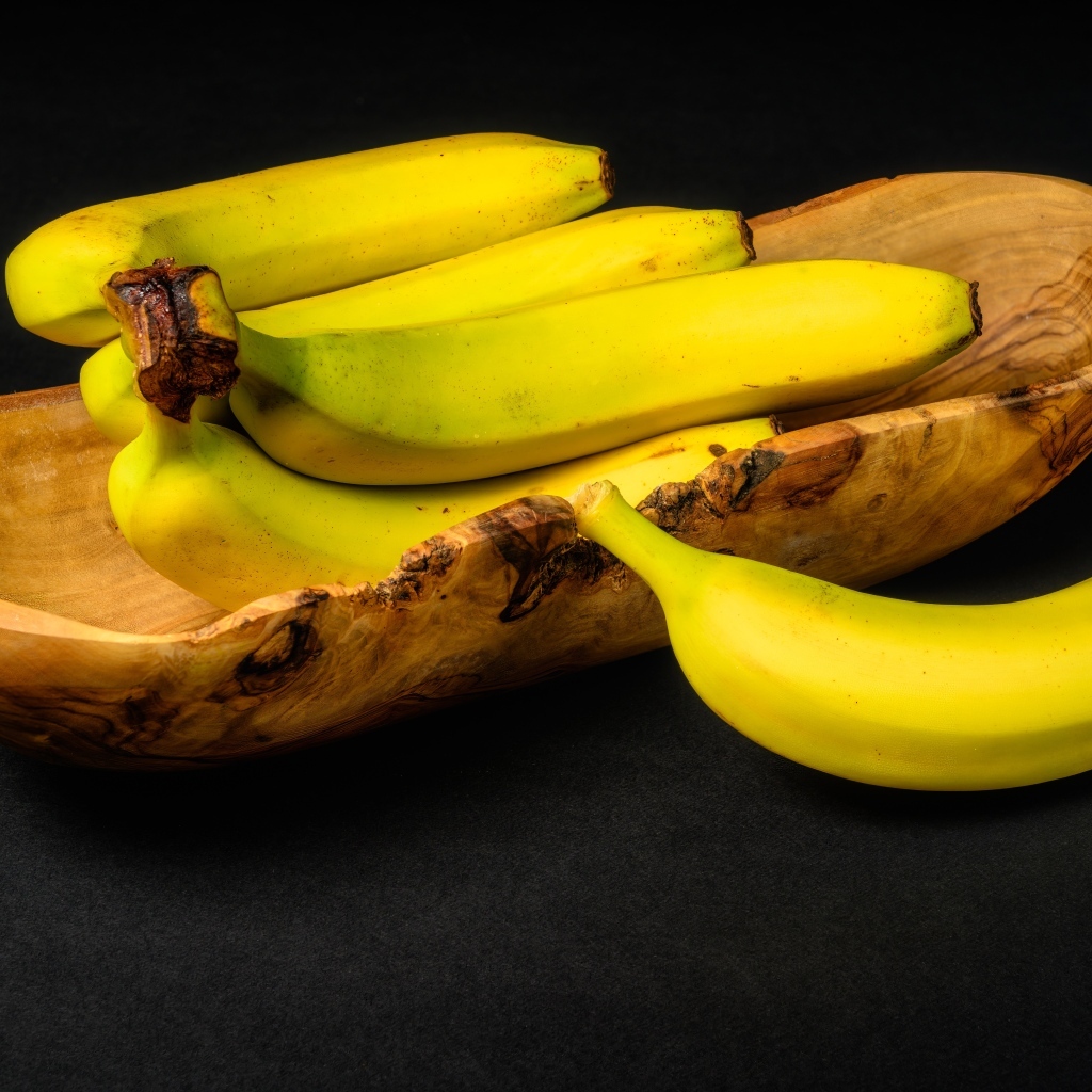 Деревянная чаша с бананами на столе