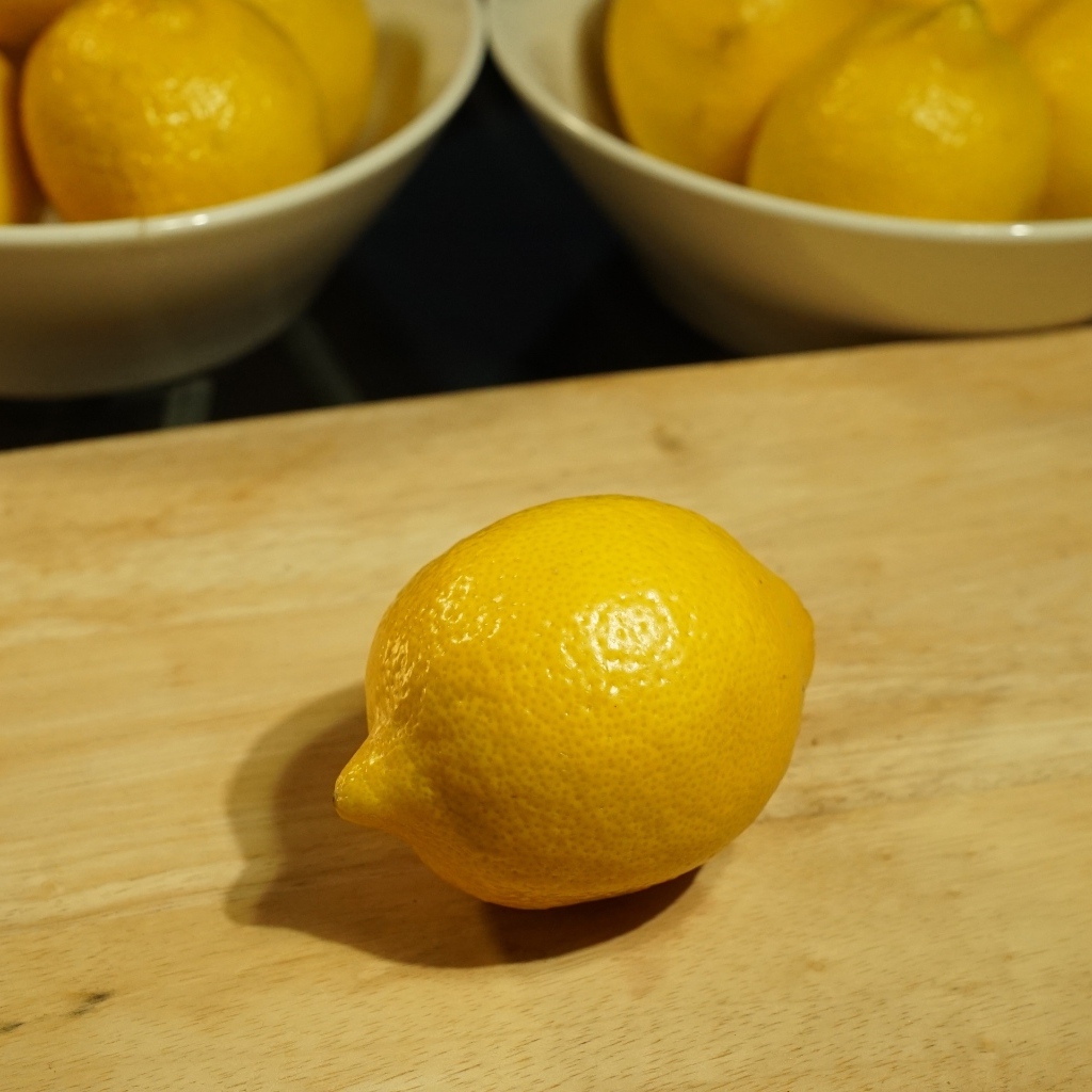 Желтый лимон на деревянной доске на столе