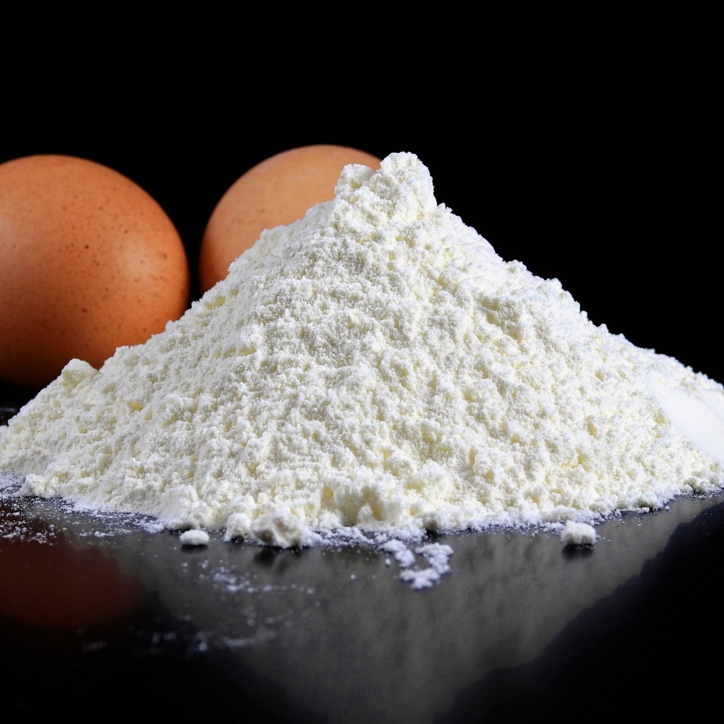 Мука на черном столе с куриными яйцами