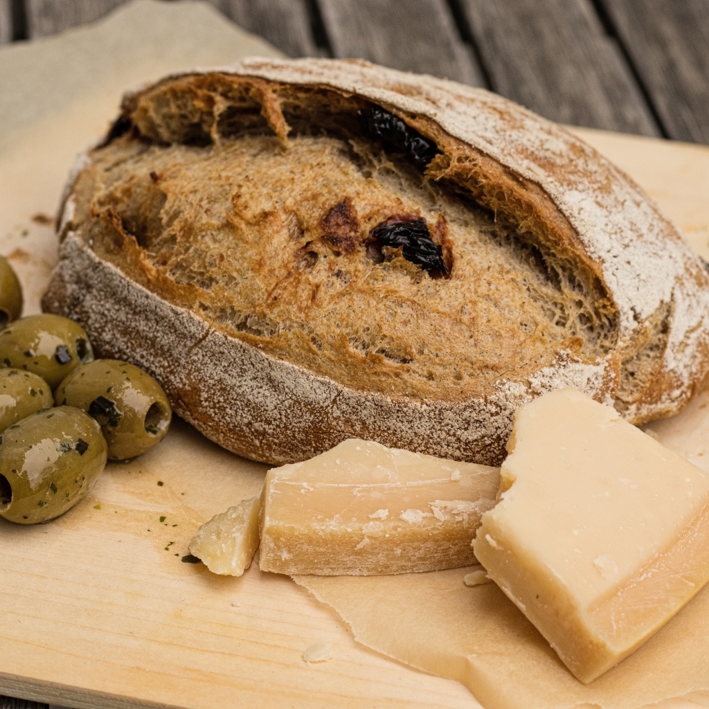 Буханка хлеба с сыром и оливками