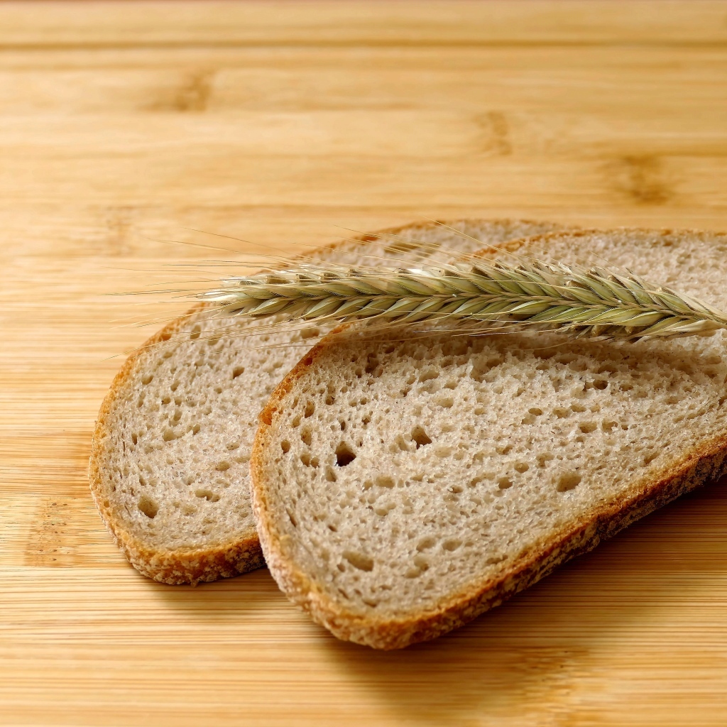 Два куска хлеба с колоском на деревянном столе