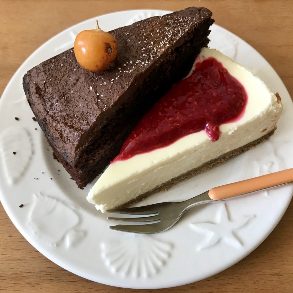 Кусок шоколадного торта и чизкейка на тарелке