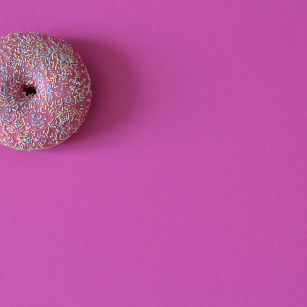 Аппетитный донат с глазурью на розовом фоне