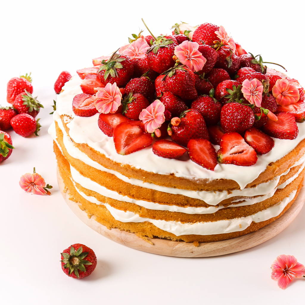 Торт со сметанным кремом и ягодами клубники на белом фоне
