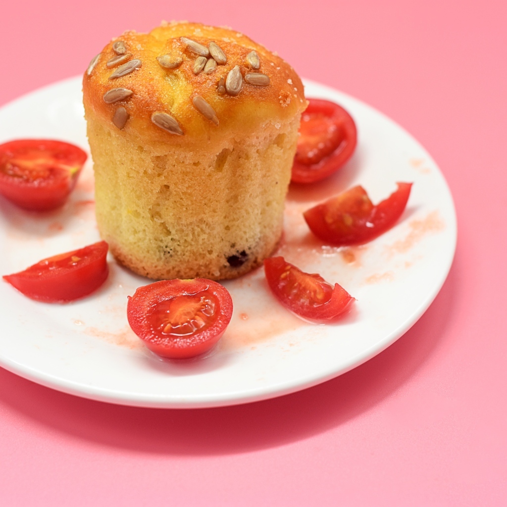 Кекс с помидорами черри на белой тарелке