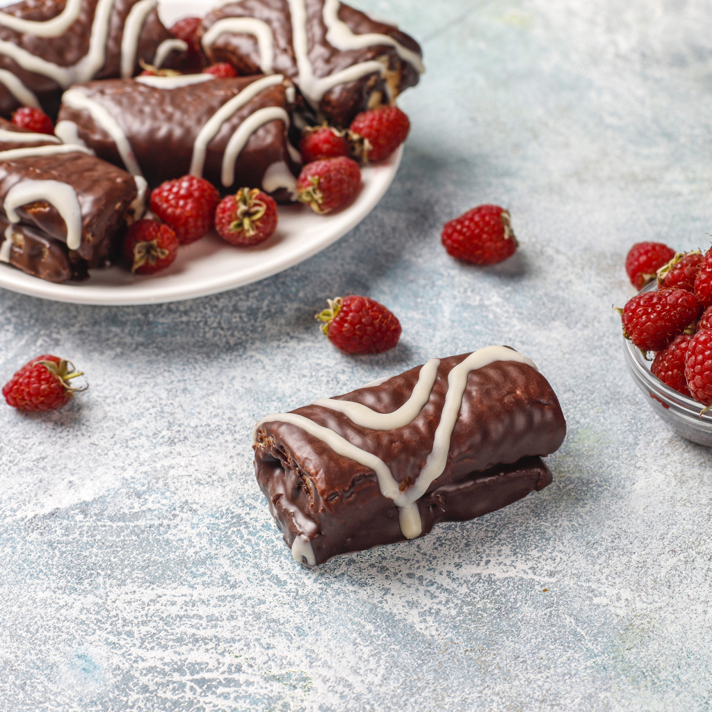 Шоколадные рулетики с ягодами малины на столе