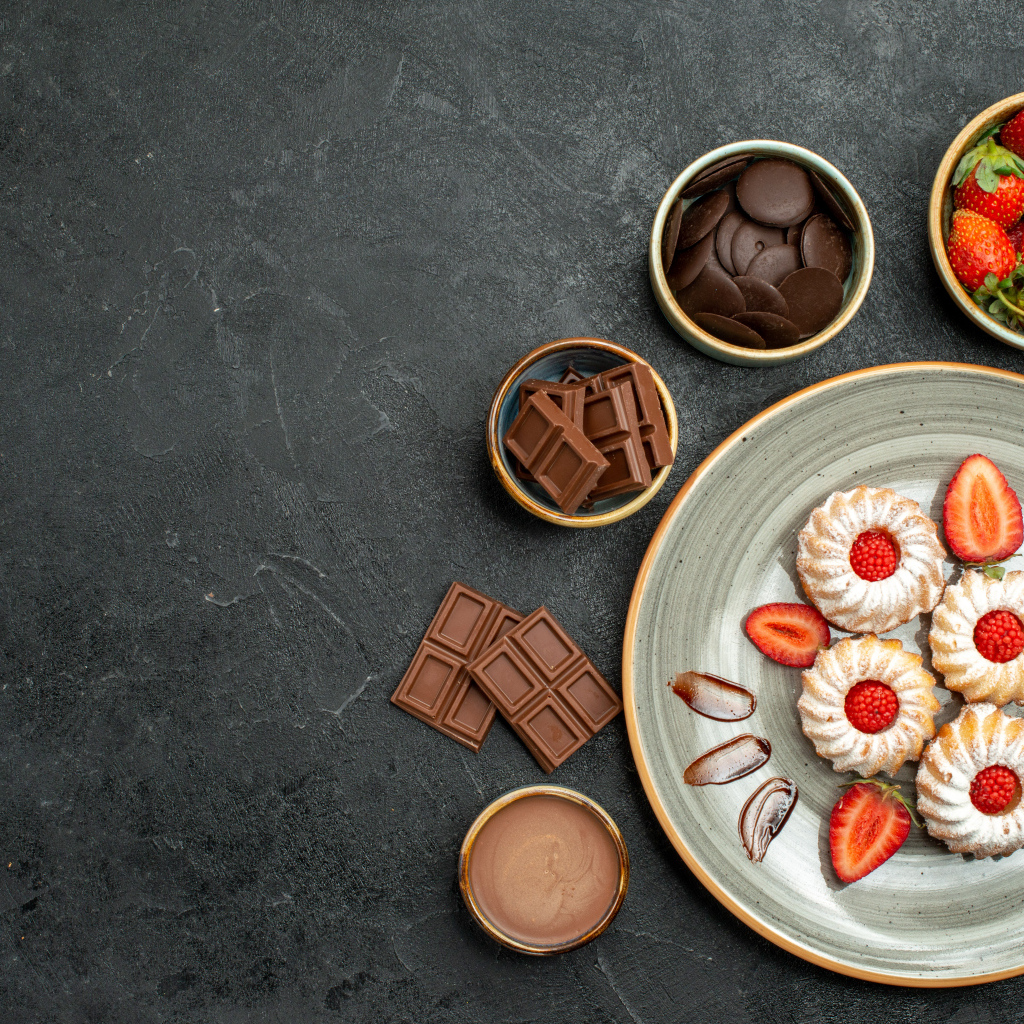 Печенье на столе с шоколадом и ягодами клубники