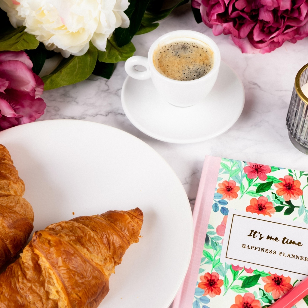 Круассаны на столе с кофе и цветами