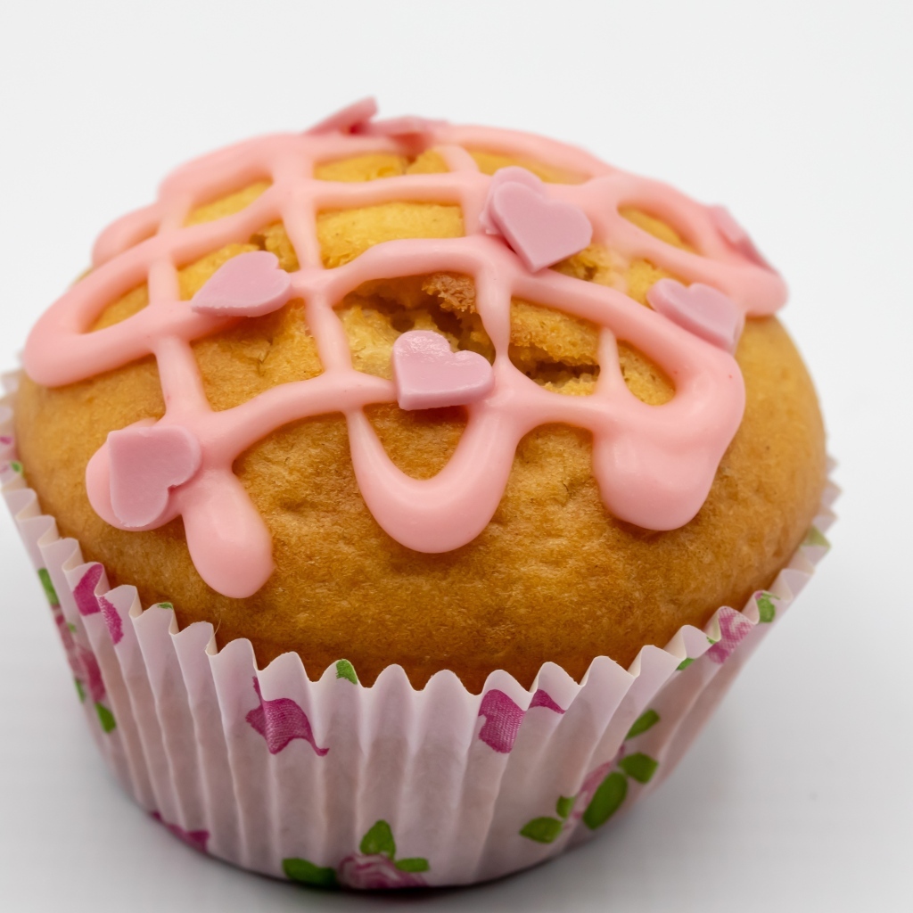 Кекс с клубничной глазурью на сером фоне