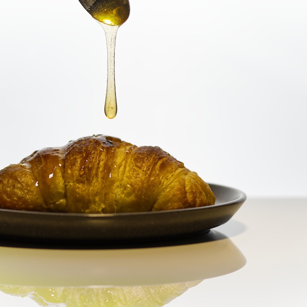 Свежий круассан с медом на завтрак