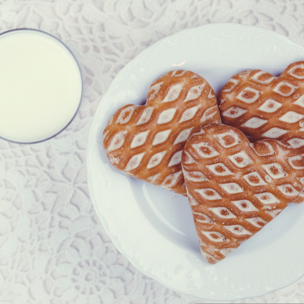 Печенье в форме сердца на столе с молоком