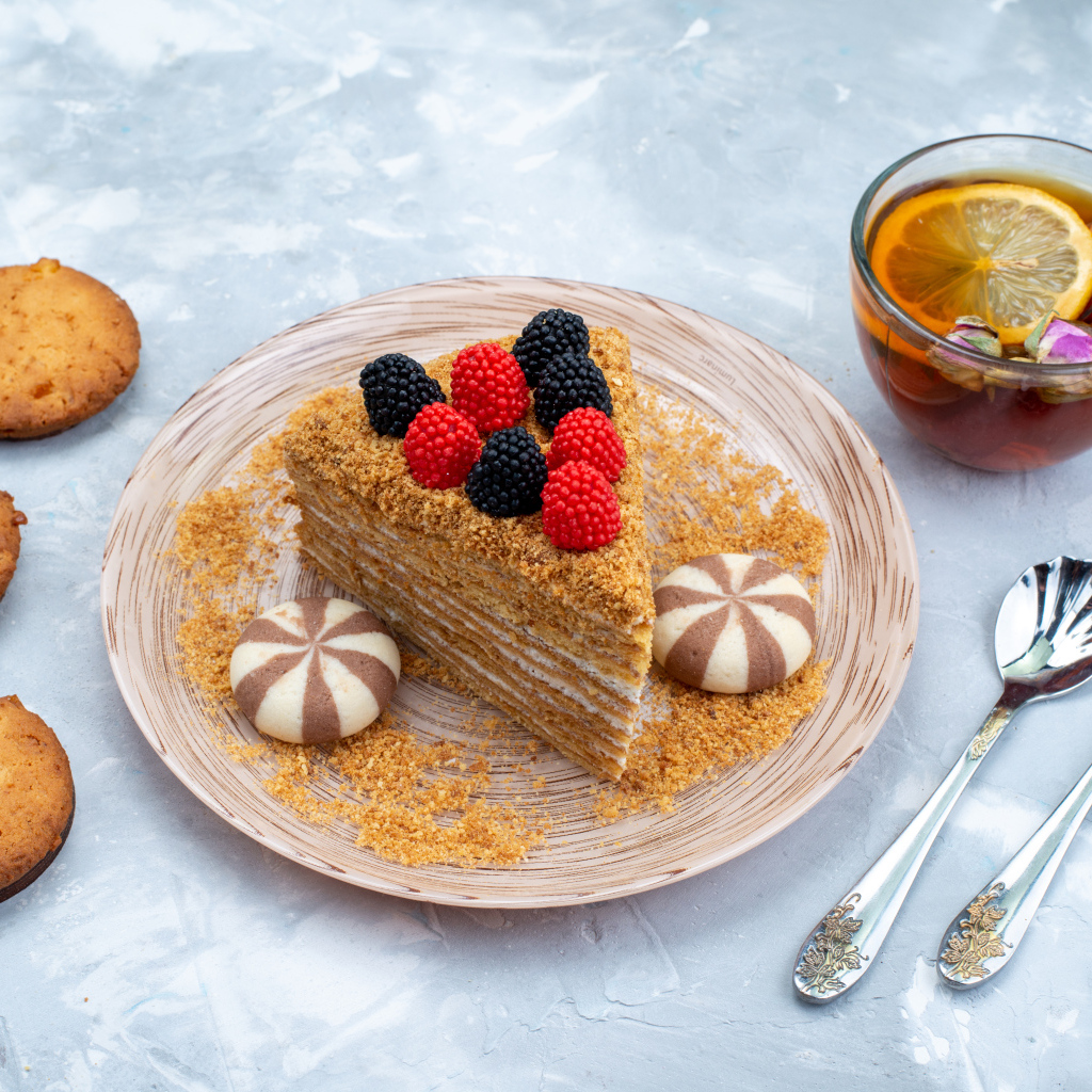 Торт медовик с чаем и печеньем на столе