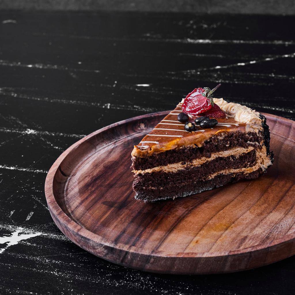 Большой кусок торта на деревянной доске