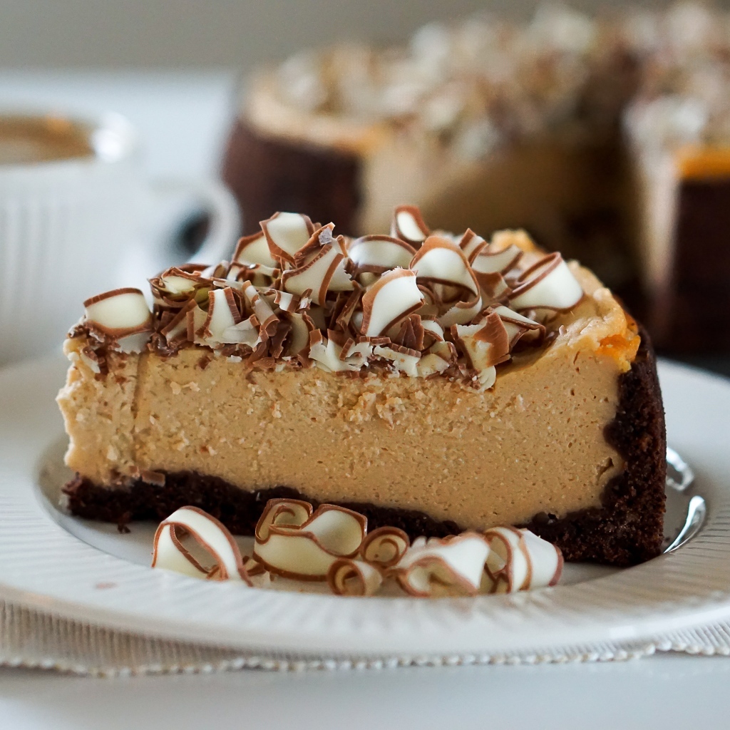 Кусок торта с шоколадной стружкой на белой тарелке