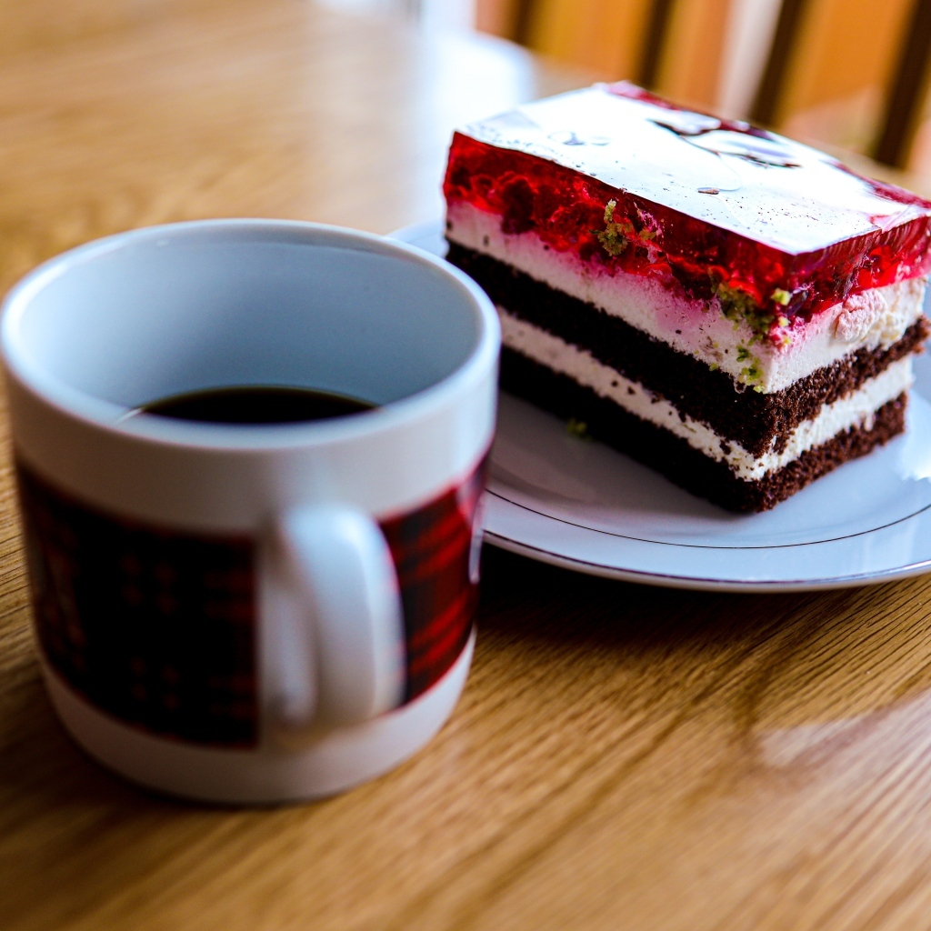Кусок торта с чашкой кофе на деревянном столе