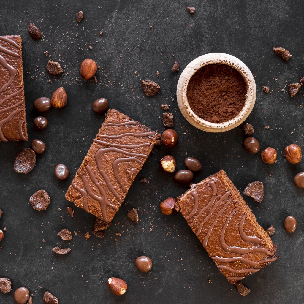 Кусочки пирожных на сером столе с шоколадными зернами