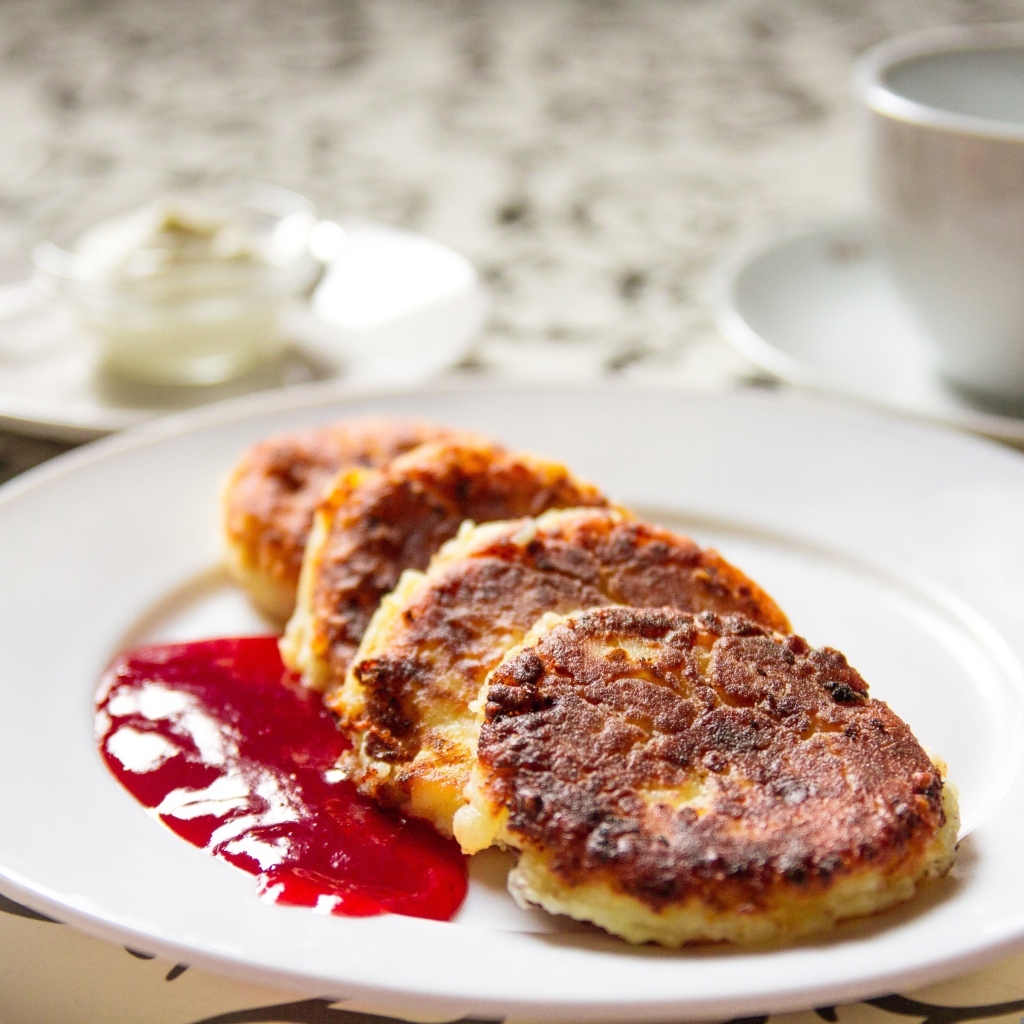 Румяные сырники на тарелке с джемом на завтрак