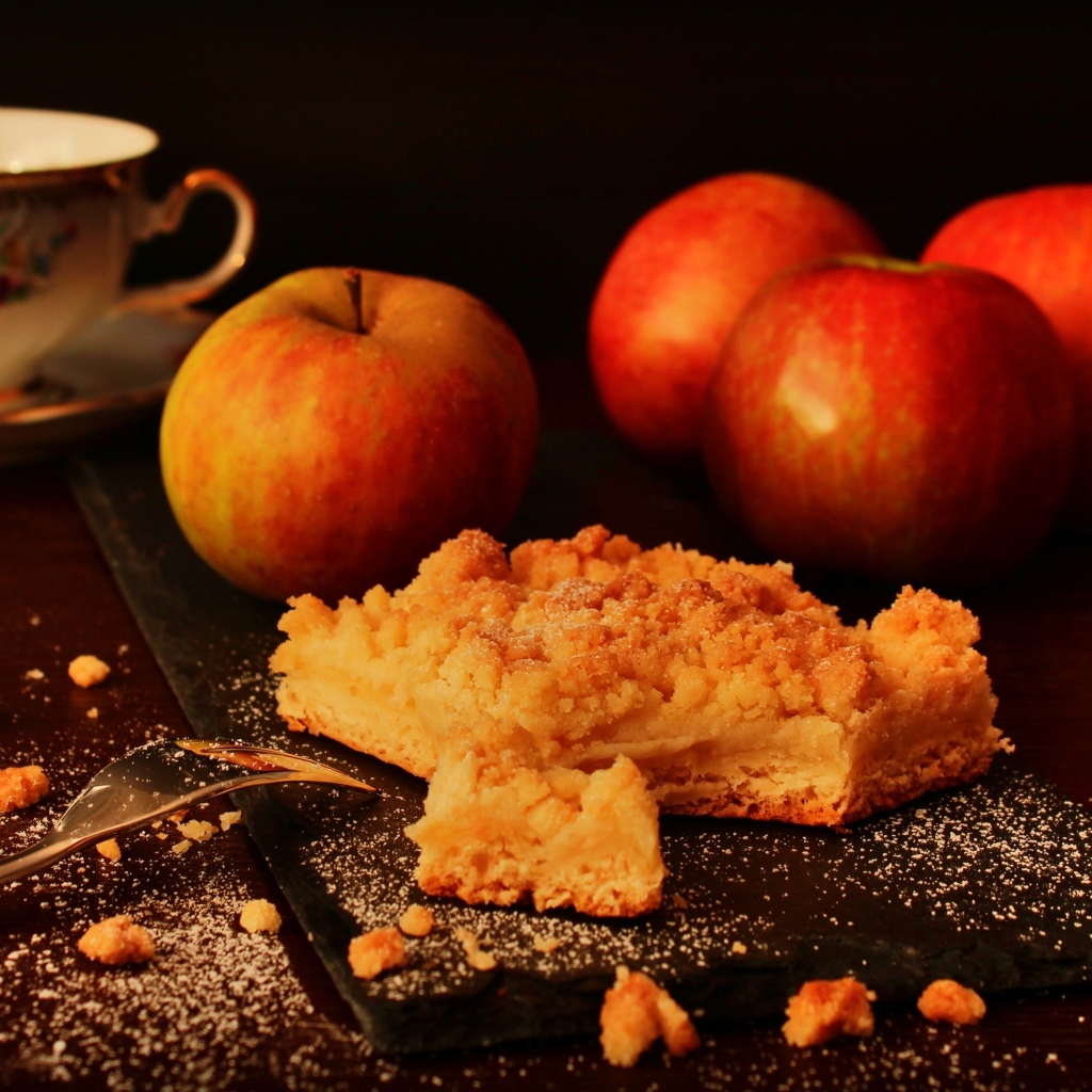 Песочный яблочный пирог на столе с яблоками