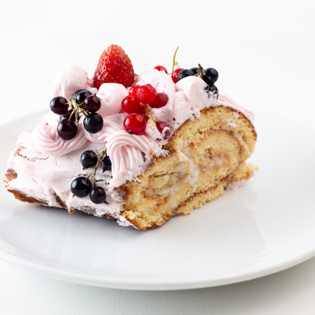 Ломтик сладкого рулета с ягодами и кремом