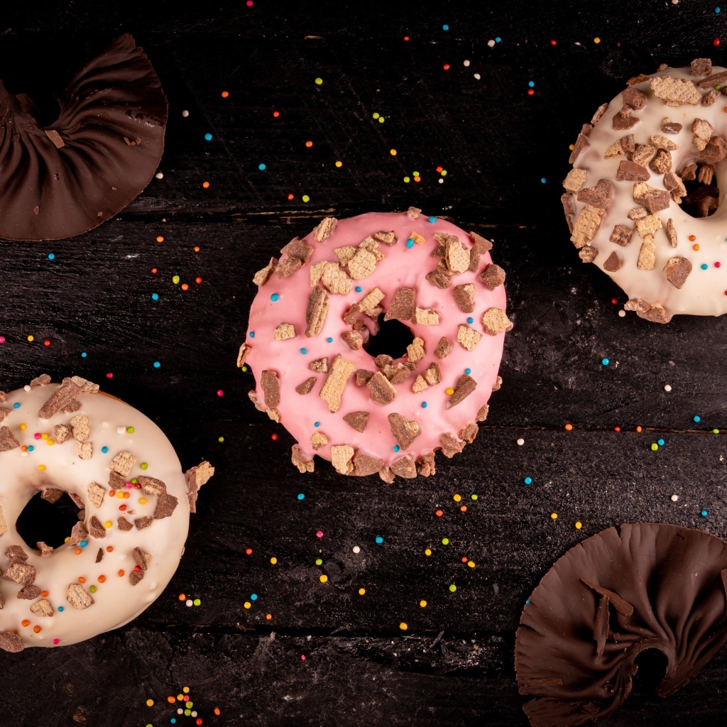 Три сладких пончика на черном столе