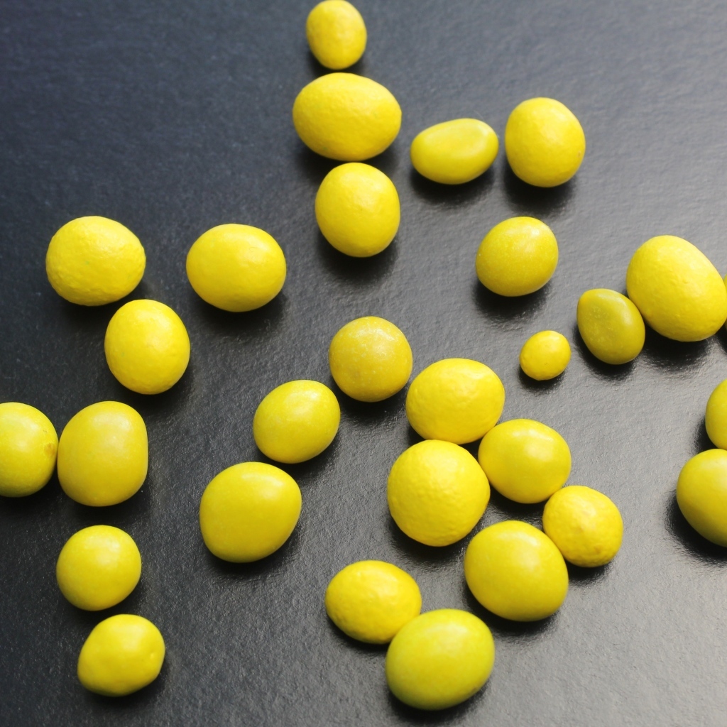 Желтые конфеты на сером столе