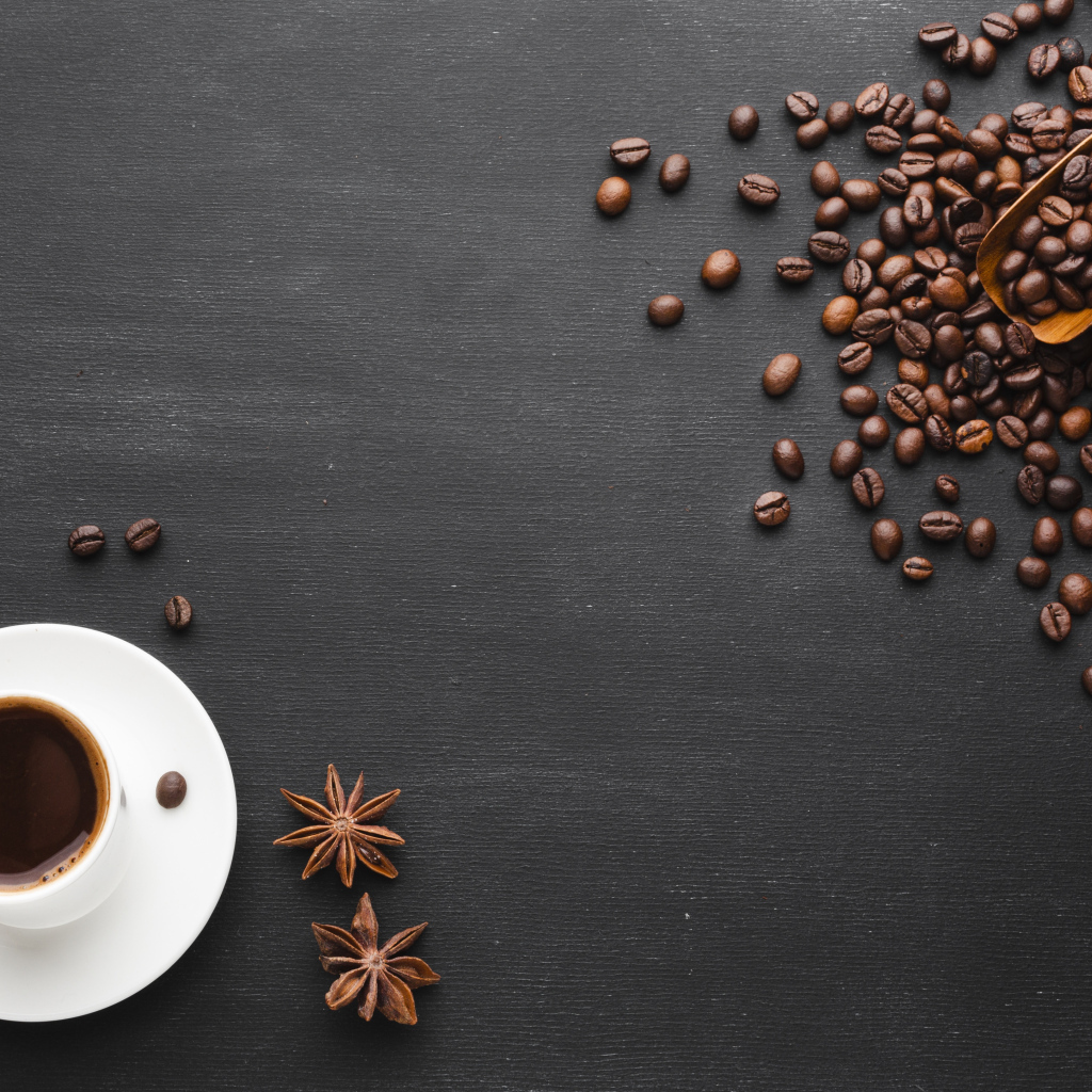 Чашка кофе на черном столе с зернами