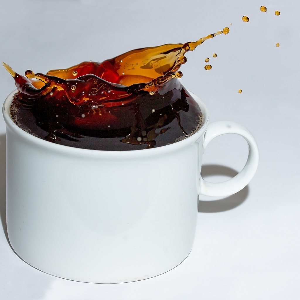 Чашка кофе с брызгами на сером столе