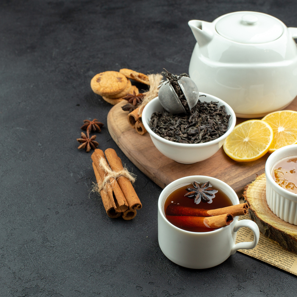 Вкусный чай на столе с лимоном и пряностями