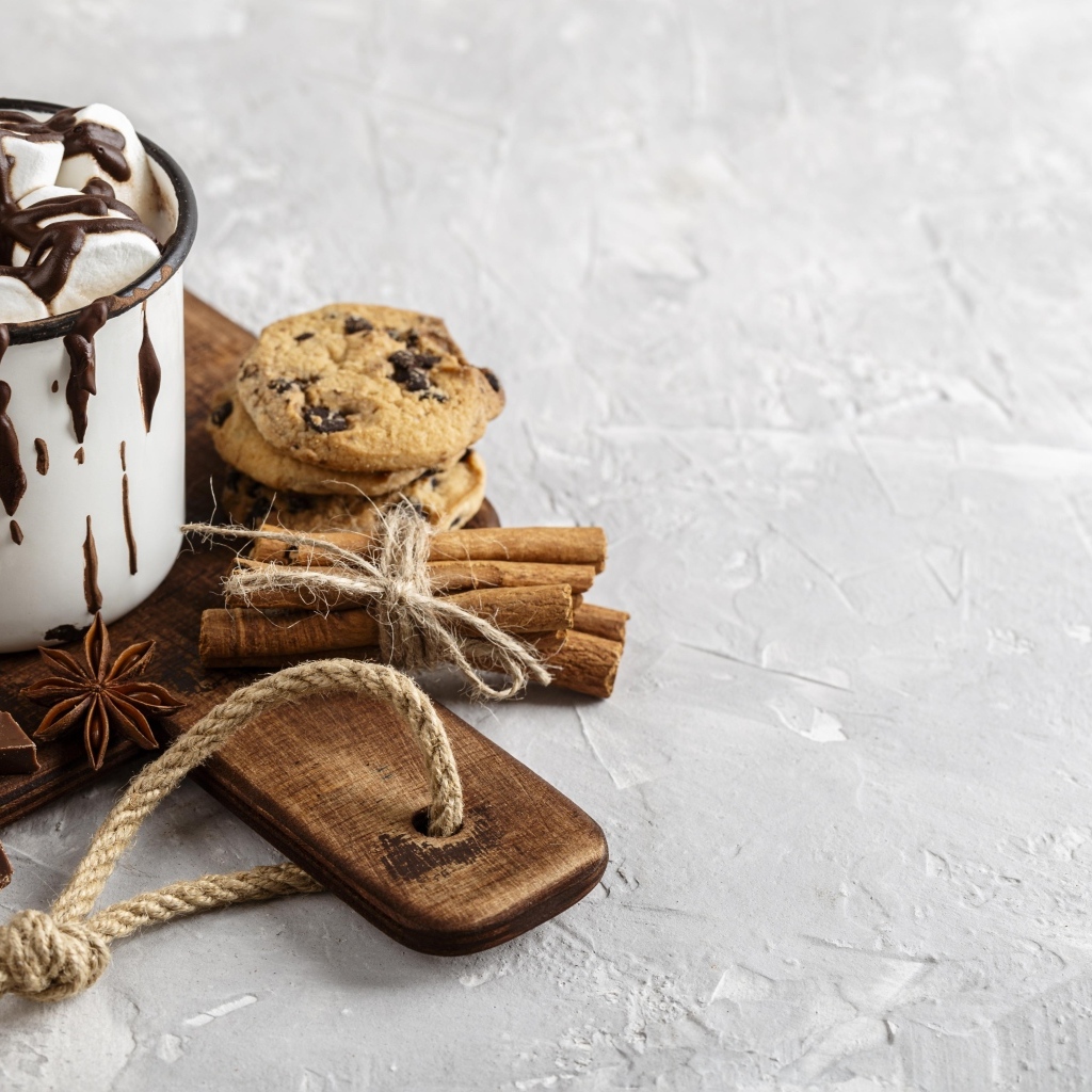 Горячий шоколад с маршмеллоу на столе с печеньем и конфетами