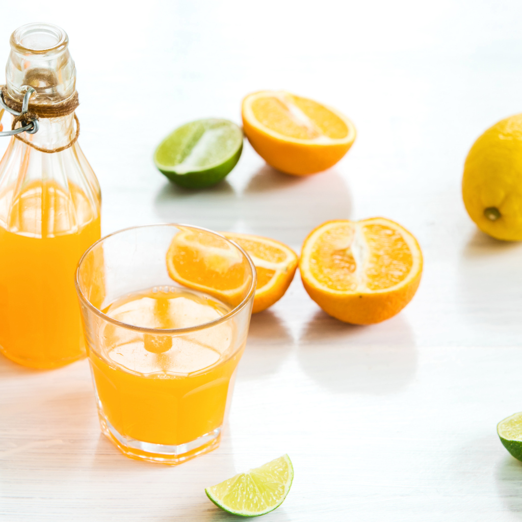 Апельсиновый сок на столе с фруктами