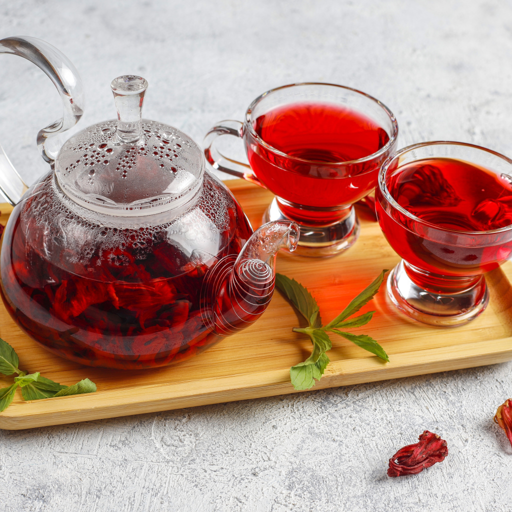Красный чай в заварнике на подносе с чашками