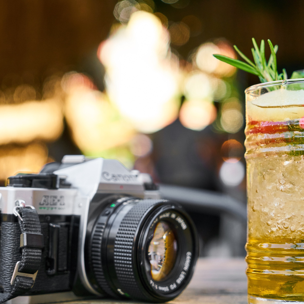 Ретро фотоаппарат с коктейлем на столе